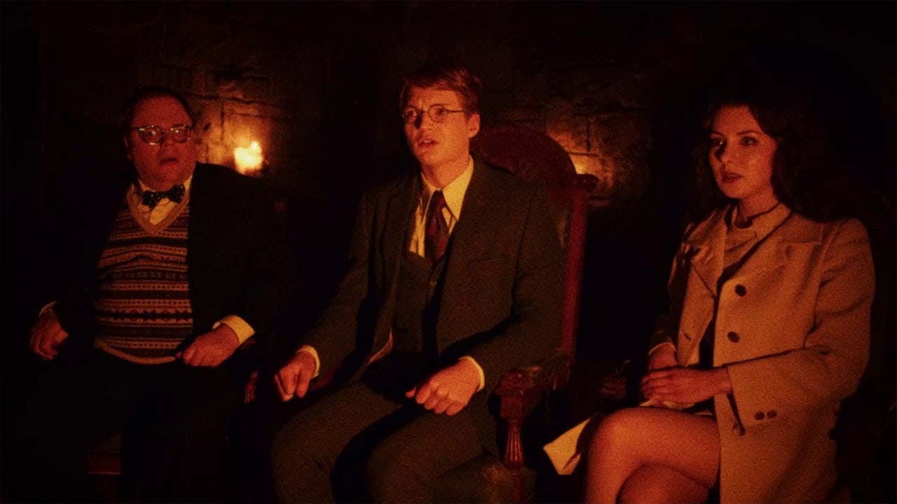 Three visitors wait in a dimly lit room in In the Grip of Terror