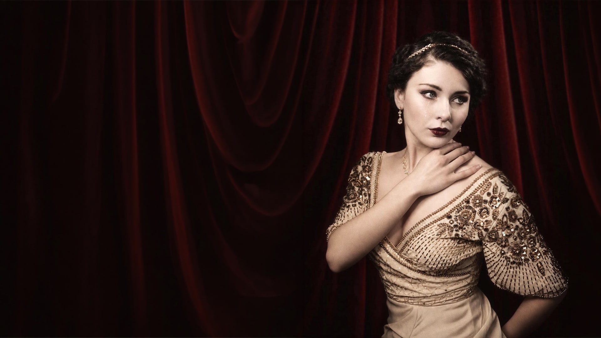 Megan Tremethick in an embroidered evening gown before burgundy theatre curtains